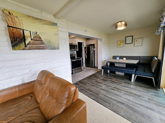 9059 Clam Lake Rd, Bellaire, MI 49615 - living room with beam ceiling, a textured ceiling, wood finished floors, and stairs