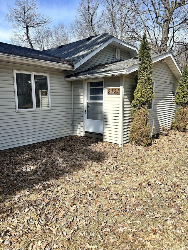 back of property with a shingled roof