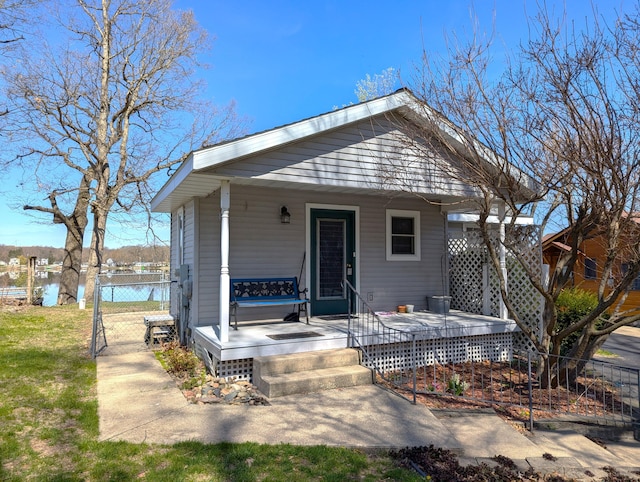 rear view of property featuring a gate, a porch, and fence