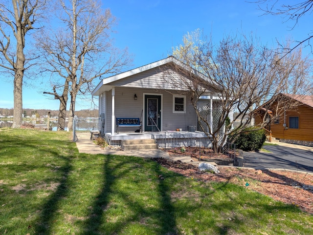 view of front of property featuring fence, a porch, and a front yard