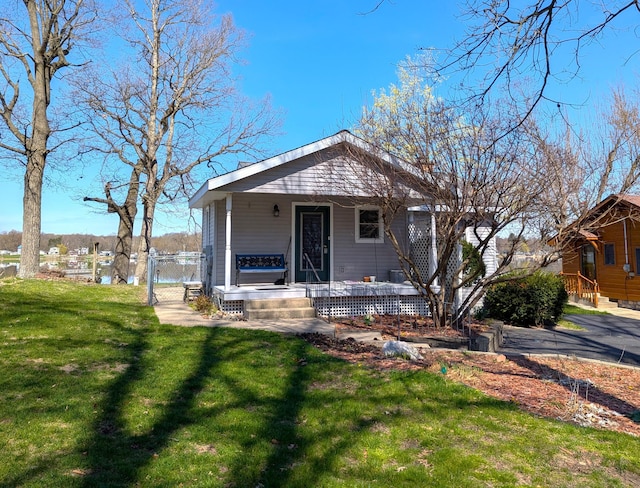view of front of home with a porch, a front lawn, and a gate