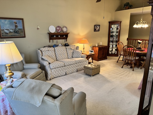 living area featuring ceiling fan with notable chandelier and carpet