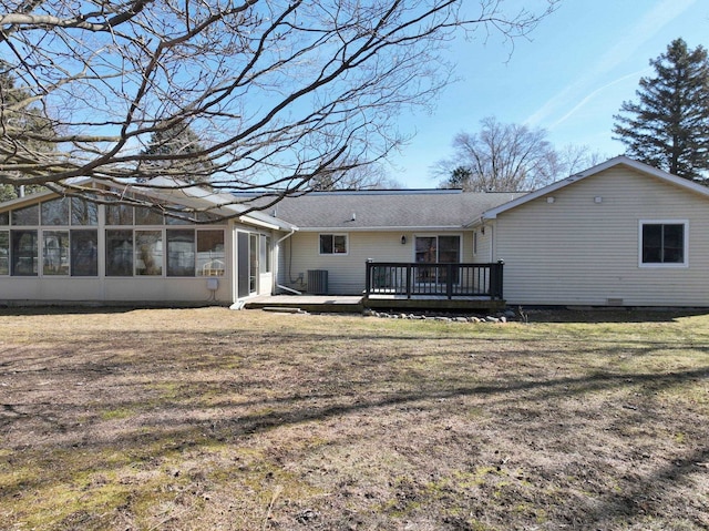 rear view of property with a yard, a deck, and a sunroom