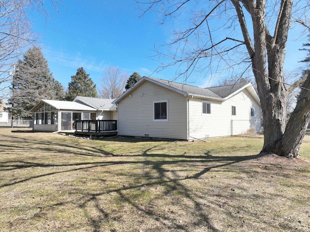 view of home's exterior featuring a lawn, a deck, and a sunroom