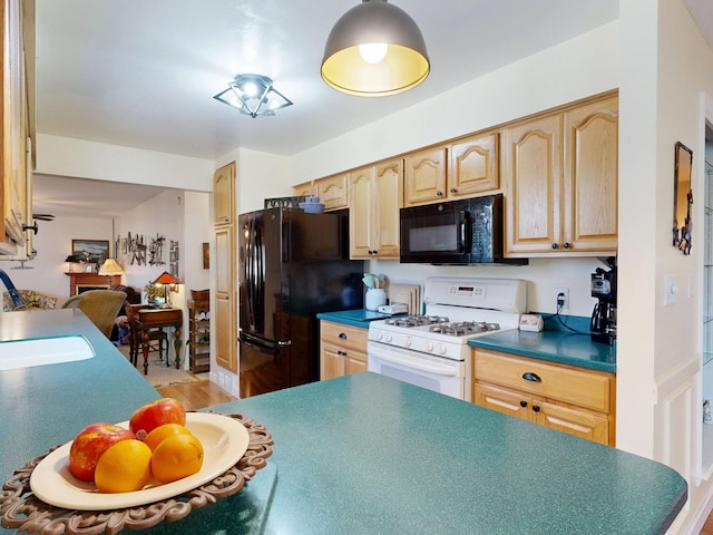 kitchen featuring dark countertops, light brown cabinets, black appliances, and a sink