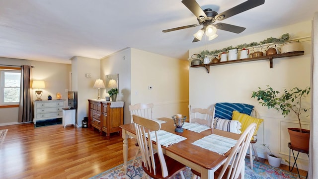 dining space with a ceiling fan and wood finished floors