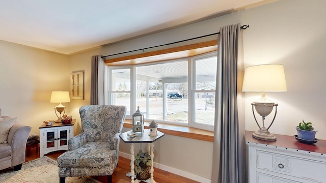 living area with baseboards and wood finished floors