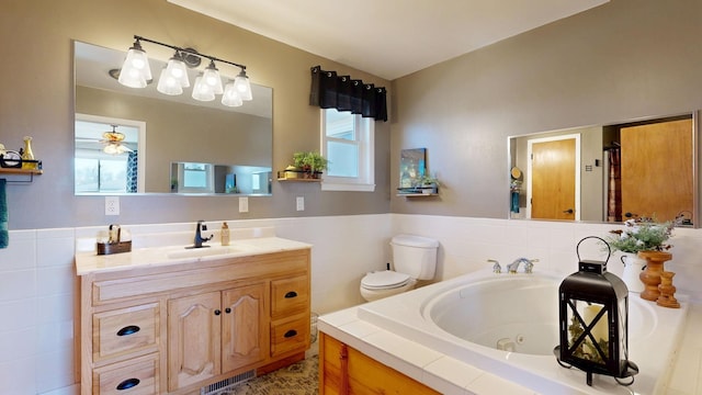 bathroom with visible vents, plenty of natural light, vanity, and a tub with jets