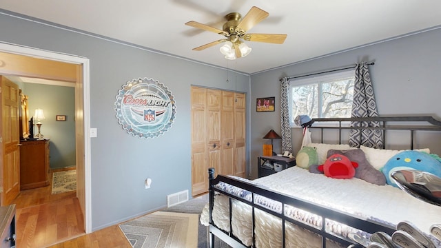 bedroom with visible vents, baseboards, light wood-style flooring, a closet, and a ceiling fan