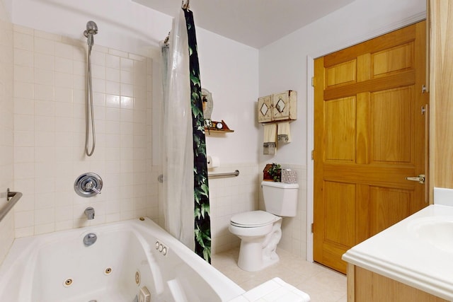 bathroom with a combined bath / shower with jetted tub, toilet, wainscoting, tile patterned floors, and tile walls