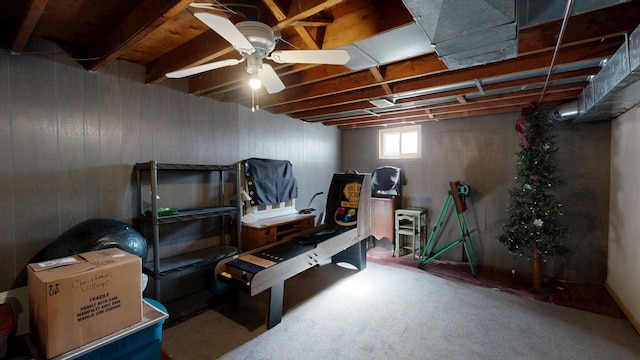 below grade area with a ceiling fan and carpet floors