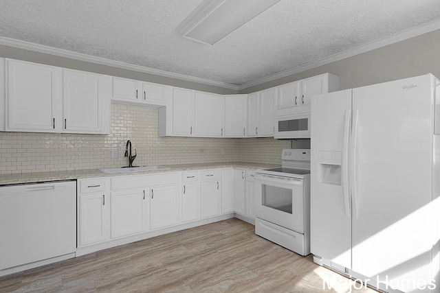 kitchen with light wood-type flooring, ornamental molding, white cabinets, white appliances, and a sink