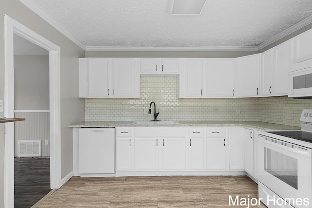 kitchen featuring light wood finished floors, visible vents, light stone countertops, white appliances, and a sink