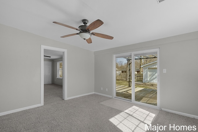 empty room featuring carpet flooring, baseboards, and ceiling fan