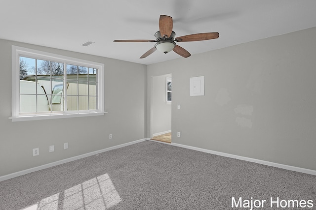 spare room with visible vents, carpet flooring, baseboards, and ceiling fan