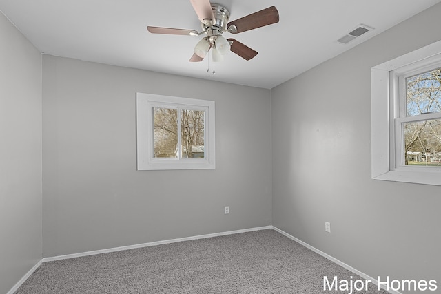 unfurnished room with carpet, baseboards, visible vents, and ceiling fan