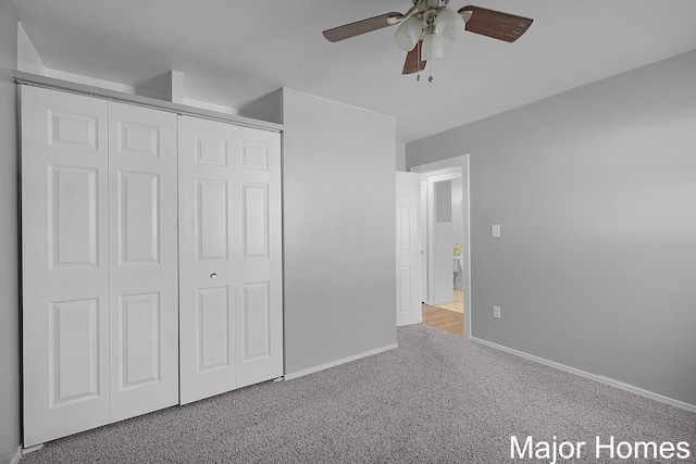 unfurnished bedroom with a closet, carpet floors, baseboards, and a ceiling fan