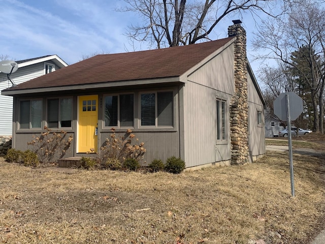 view of front of house featuring a shingled roof and a chimney