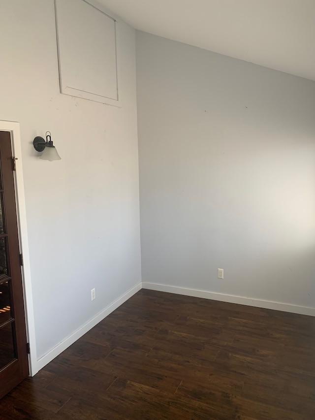 empty room featuring dark wood-type flooring and baseboards