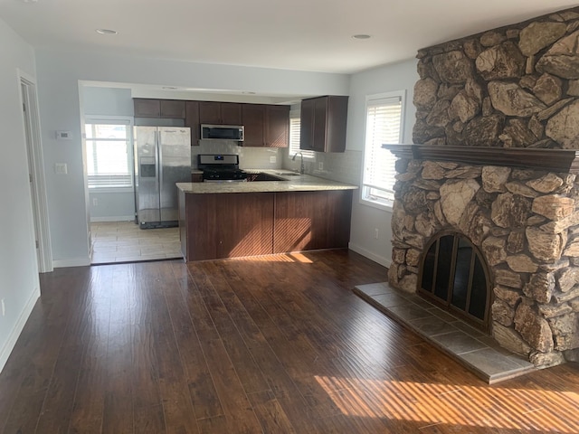 kitchen featuring a peninsula, stainless steel appliances, light countertops, and hardwood / wood-style flooring