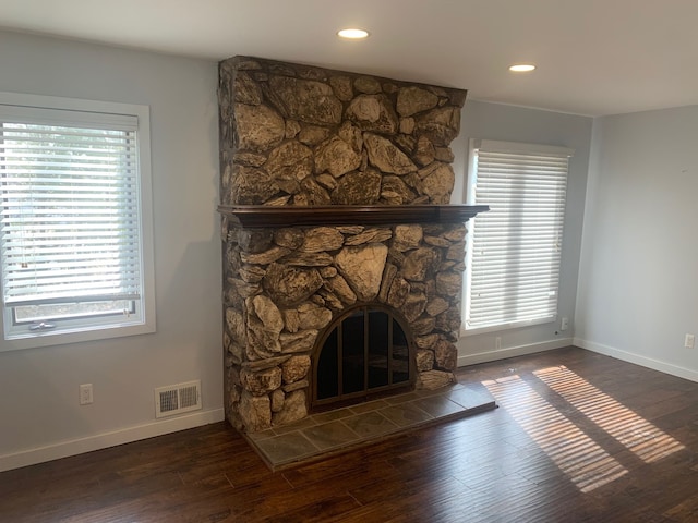 interior details with wood finished floors, visible vents, baseboards, a fireplace, and recessed lighting