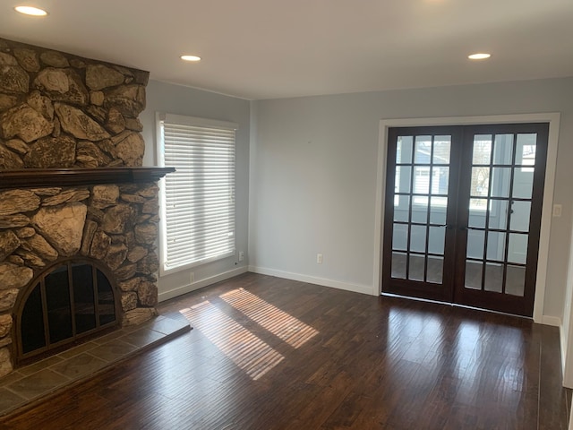 unfurnished living room with wood finished floors, plenty of natural light, and french doors