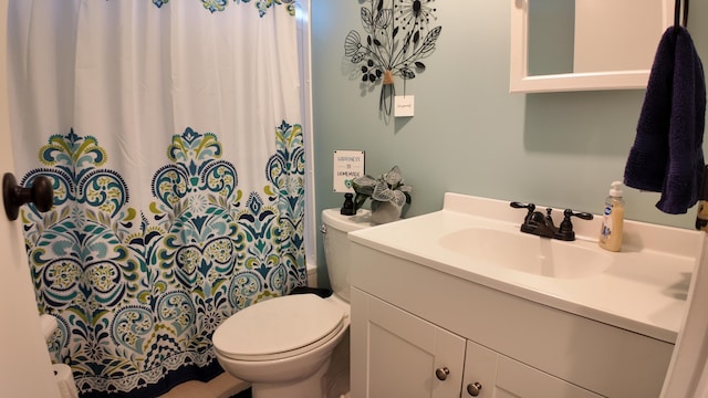 bathroom featuring a shower with curtain, toilet, and vanity