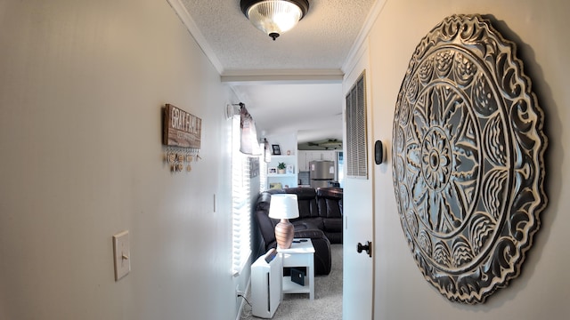 hallway with crown molding, carpet floors, and a textured ceiling