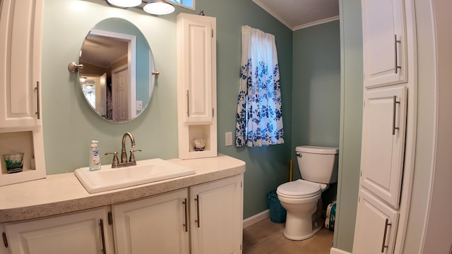 half bathroom featuring toilet, vanity, and ornamental molding