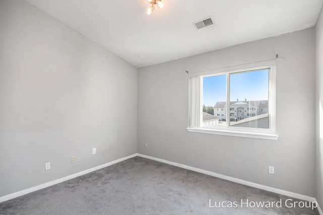 empty room with visible vents, carpet, and baseboards