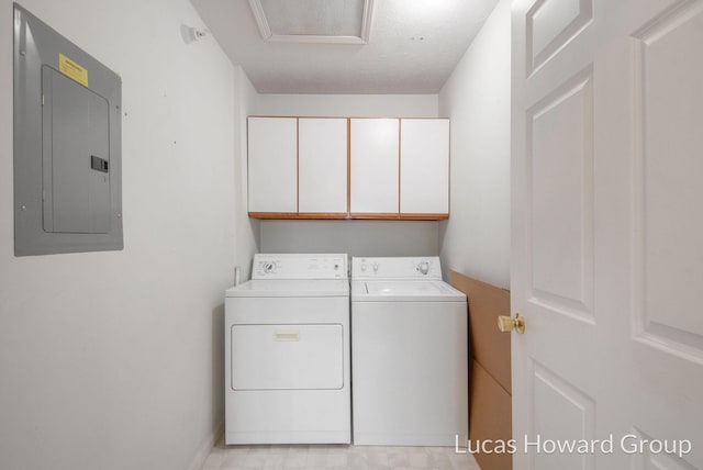 washroom with electric panel, cabinet space, a textured ceiling, and washer and dryer