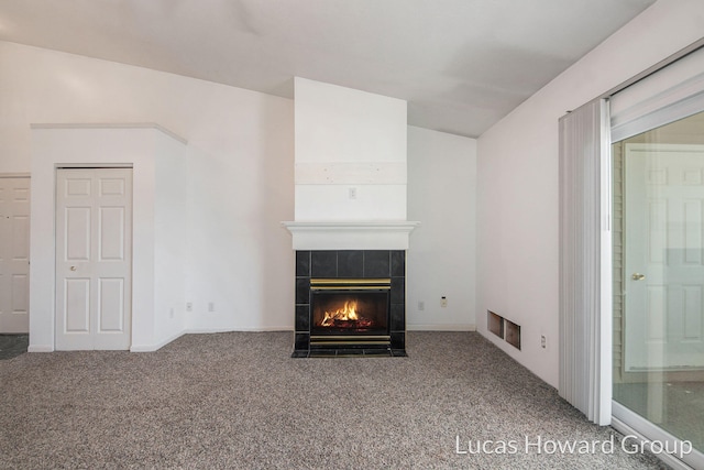 unfurnished living room with visible vents, a fireplace, lofted ceiling, and carpet floors