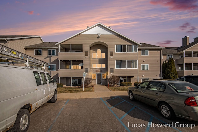 property at dusk featuring uncovered parking