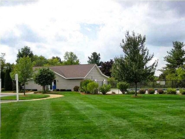 exterior space featuring a lawn and fence