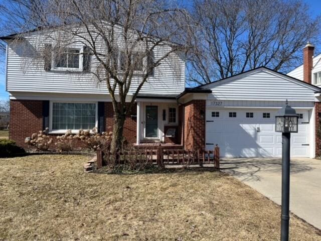 view of front of property featuring concrete driveway, brick siding, a garage, and a front yard