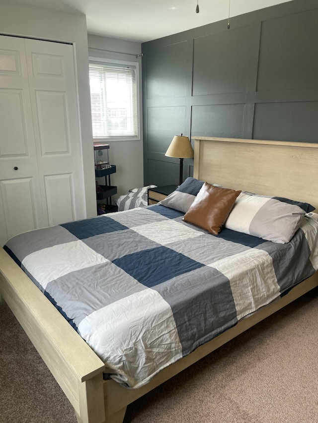 carpeted bedroom featuring a decorative wall and a closet