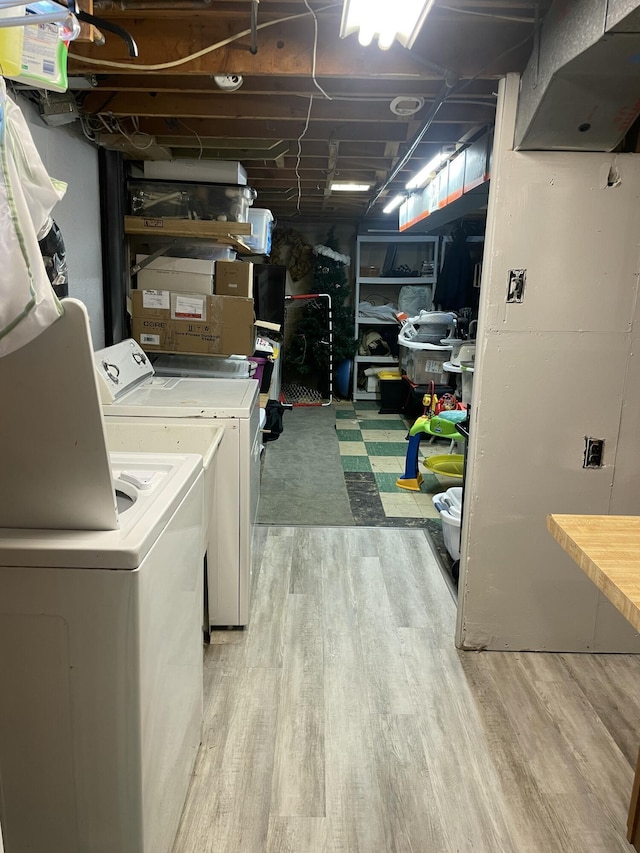 laundry area featuring washer and clothes dryer, laundry area, and wood finished floors