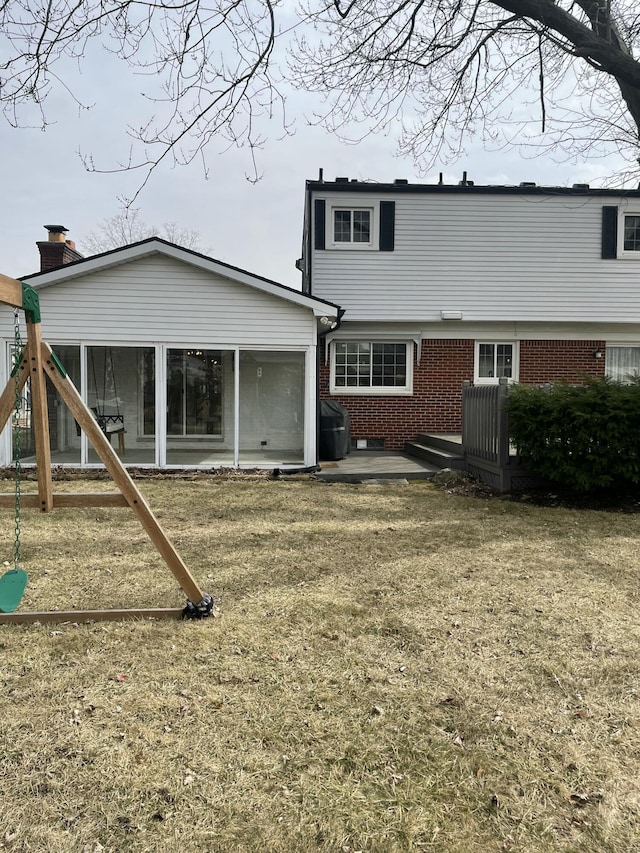 back of property featuring a patio, brick siding, and a sunroom