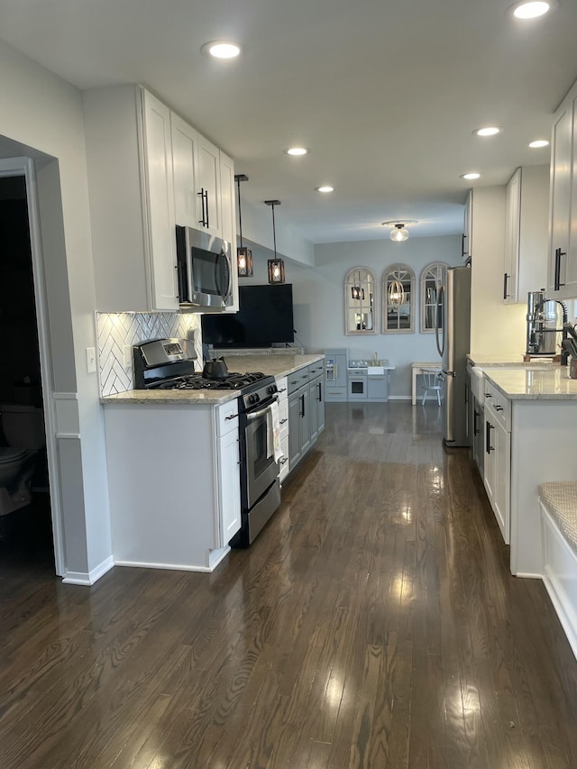 kitchen featuring stainless steel appliances, white cabinets, and dark wood-style flooring