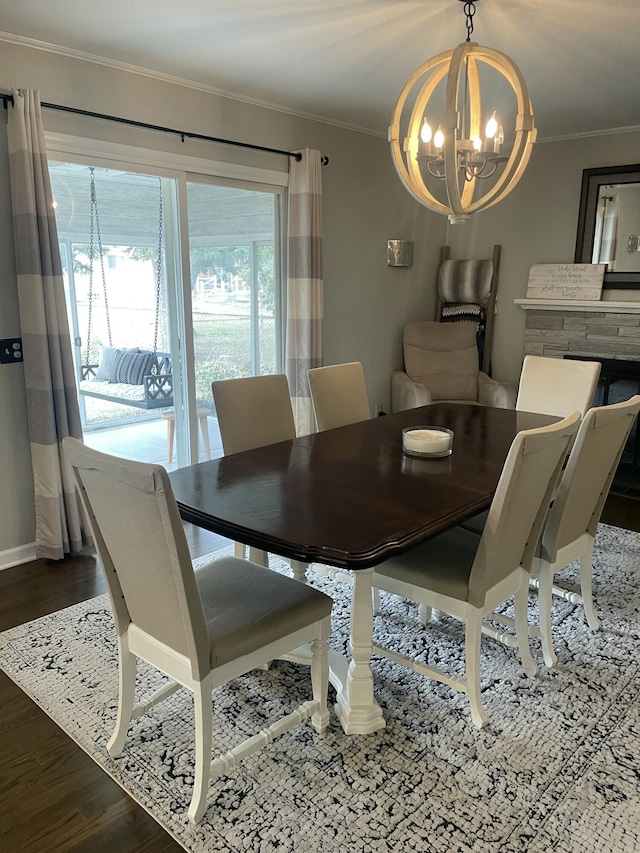 dining area with crown molding, an inviting chandelier, and wood finished floors