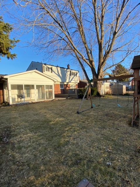 view of yard with fence and a sunroom