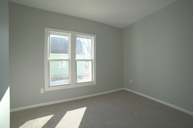 empty room with baseboards and carpet