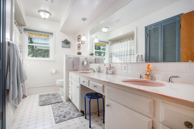 bathroom featuring a wealth of natural light, tile walls, and a sink