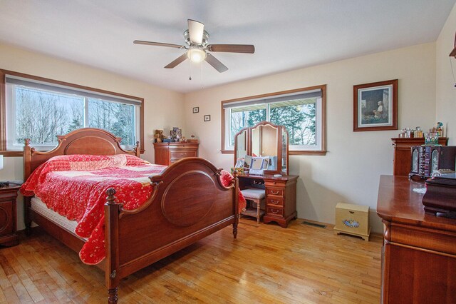 bedroom featuring multiple windows, light wood-style floors, and ceiling fan