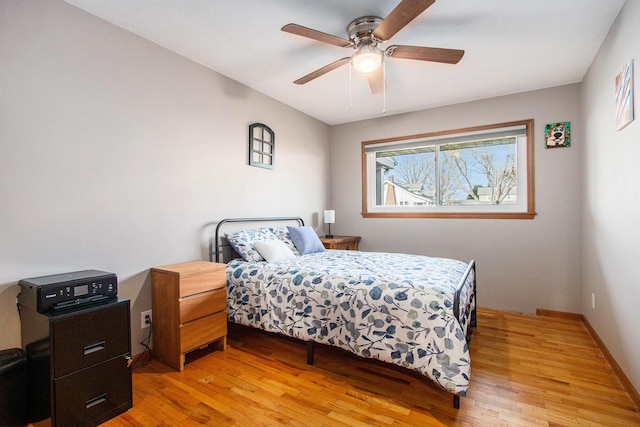 bedroom with a ceiling fan, light wood-type flooring, and baseboards