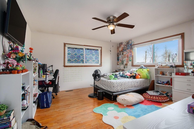 bedroom featuring a ceiling fan, visible vents, and light wood finished floors
