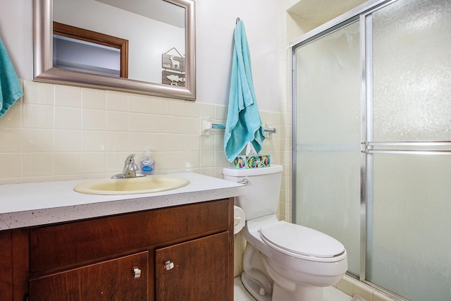 full bathroom featuring vanity, a shower stall, toilet, and tile walls