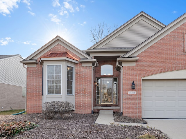 doorway to property featuring brick siding and an attached garage