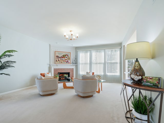 carpeted living area with baseboards, a brick fireplace, and an inviting chandelier