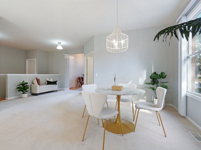 dining room featuring visible vents, light carpet, baseboards, and a chandelier